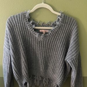 This is a warm blue/grey knitted sweater in a size Medium.